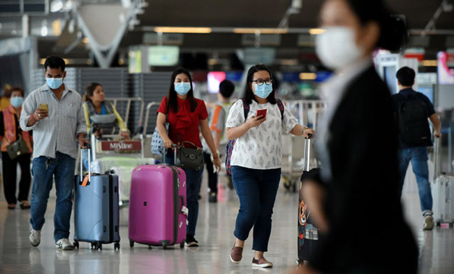 Air-travelers-wearing-masks-walk-through-departures-hall.jpg